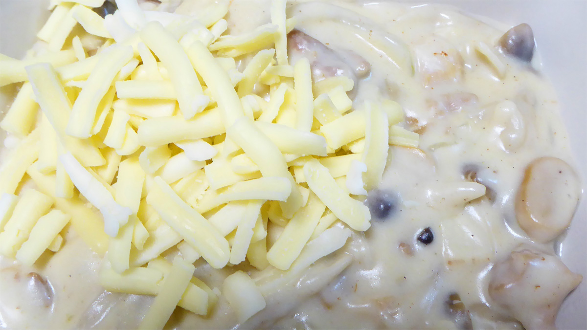グラタン皿にとりわけ、チーズを振りかける
